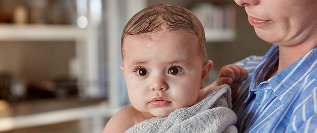 Bebê enrolado em uma toalha após o banho