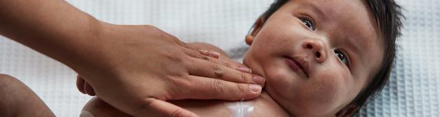 Bebê sendo massageado no peito