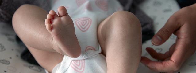 Bebê sendo massageado nas pernas