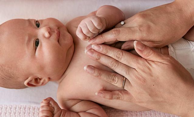 Mãos massageando o peito de um bebê